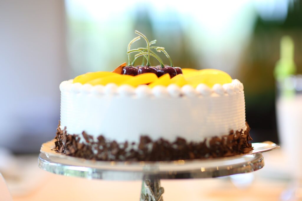 white round cake topped with yellow slice fruit