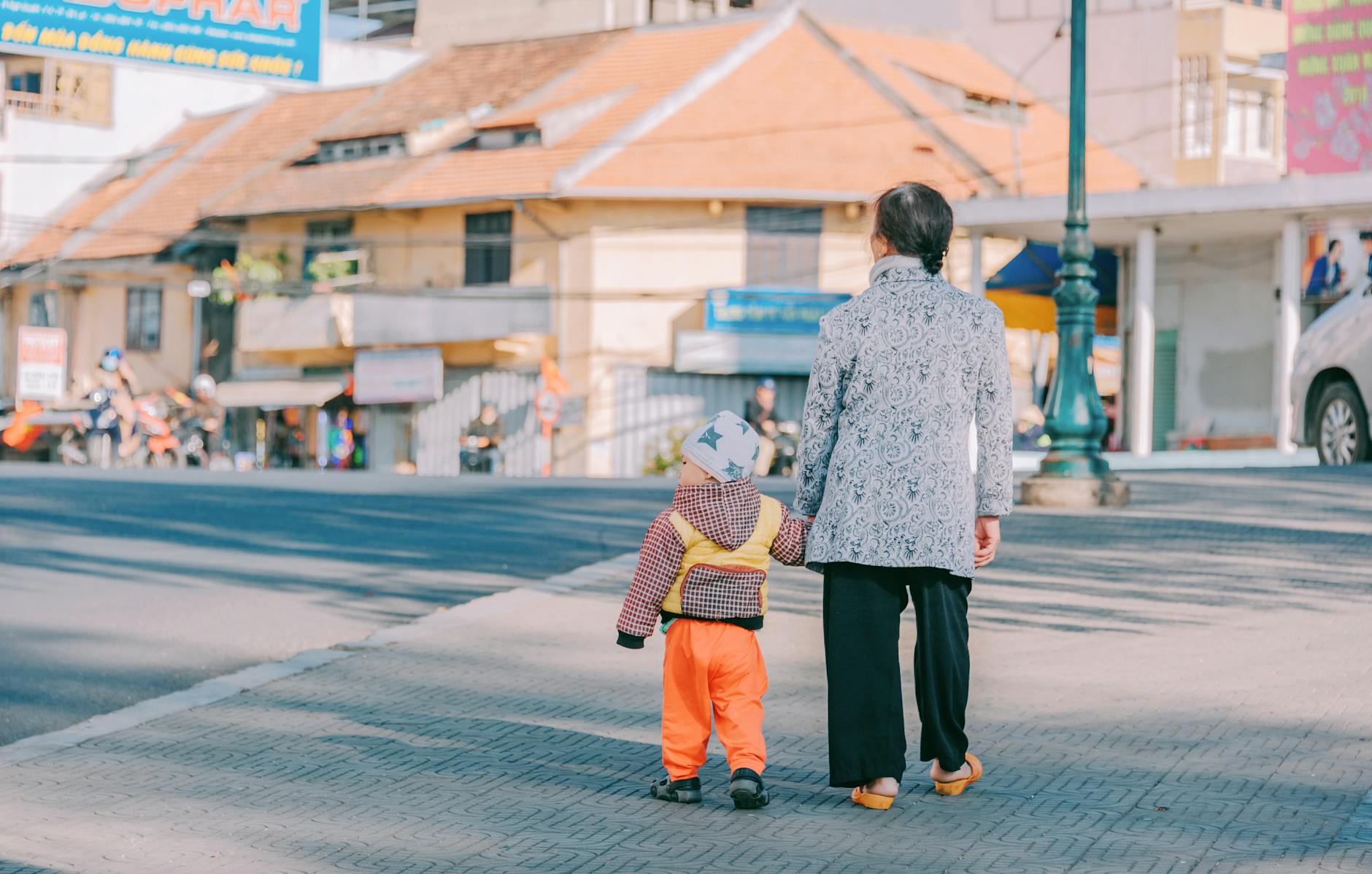 woman and boy walking at road