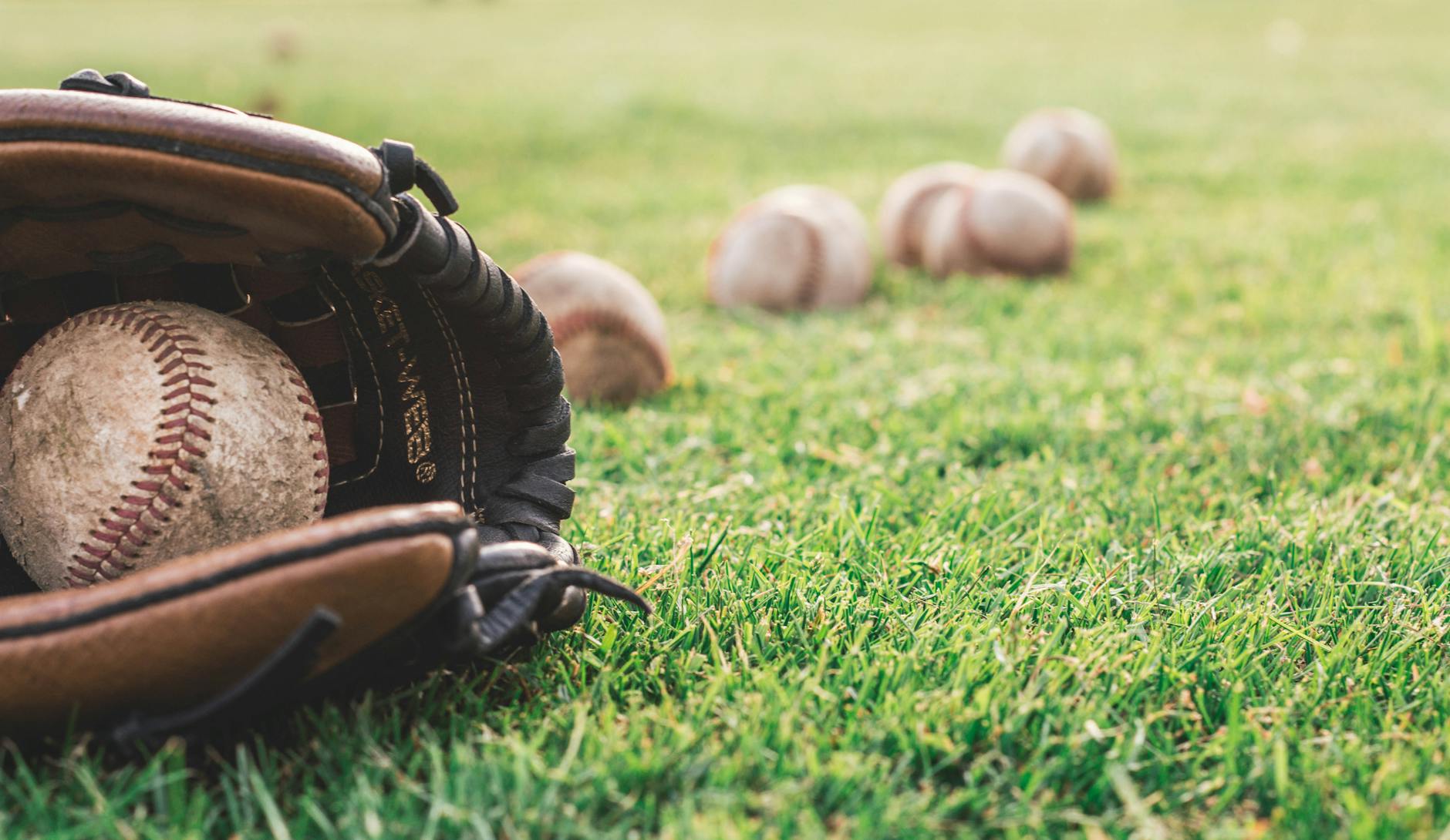 white baseball ball on brown leather baseball mitt