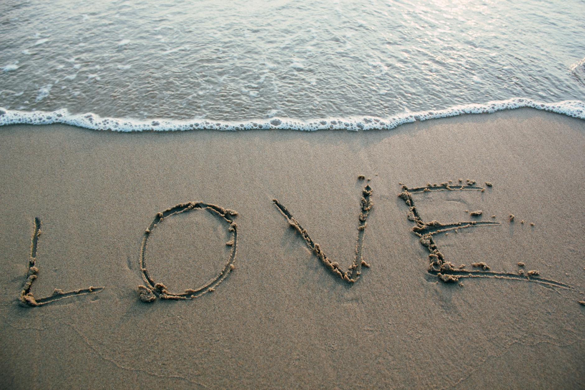 brown sand love text on seashore