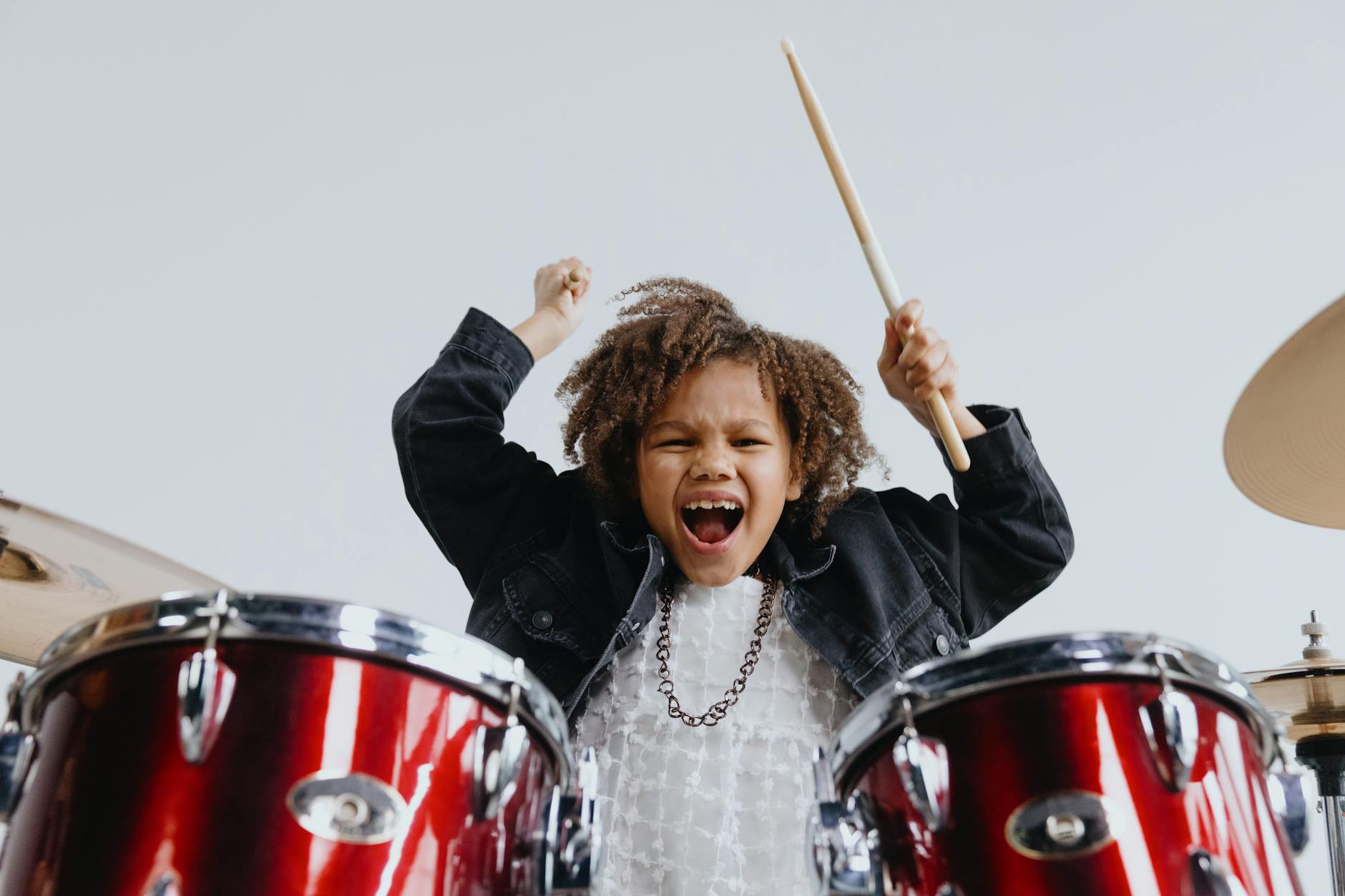 happy little girl playing drums