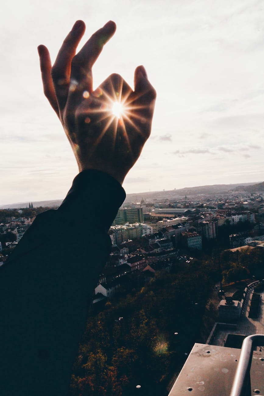 force perspective photography of hand and sun