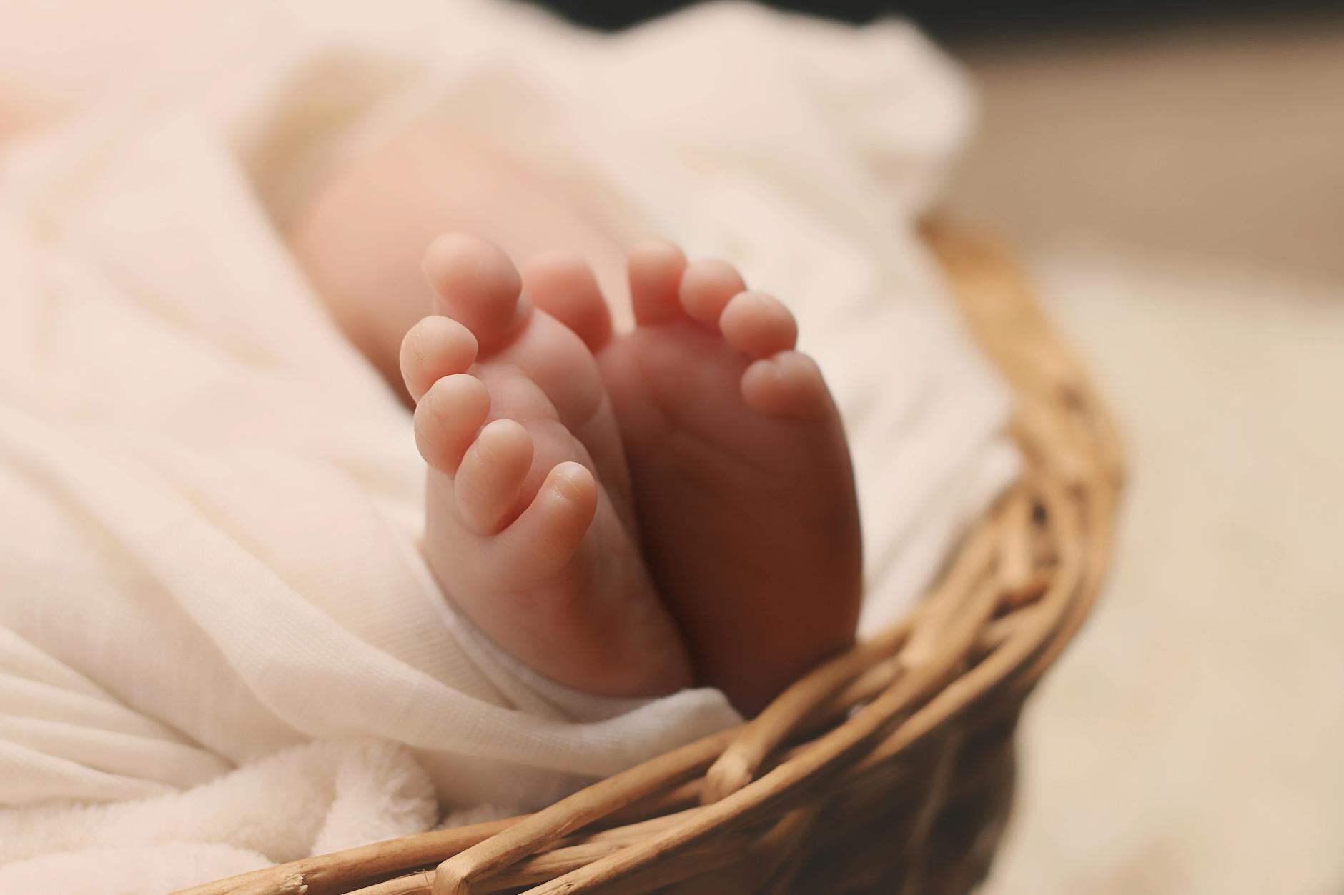 baby s feet on brown wicker basket