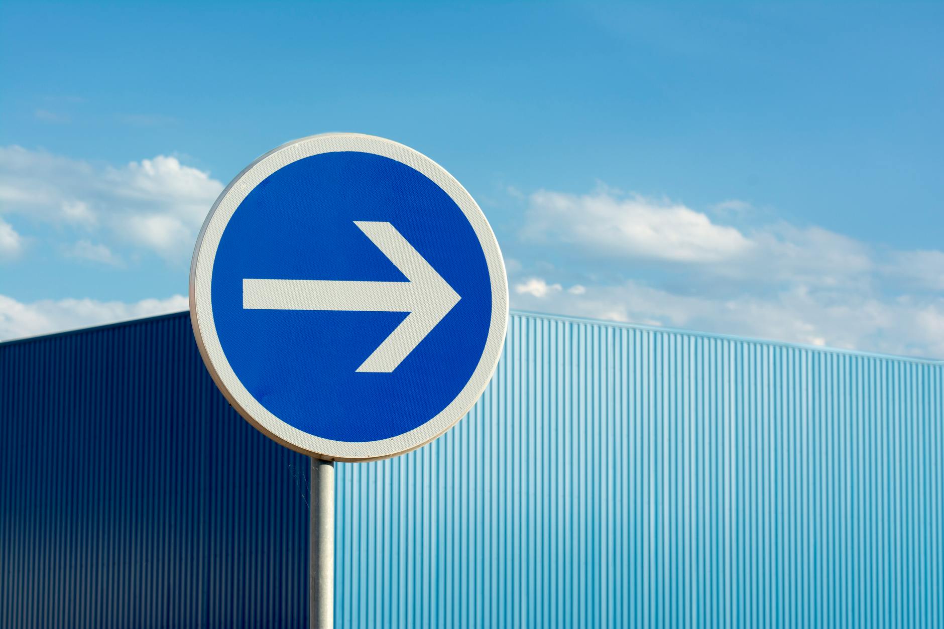 blue road sign with arrow