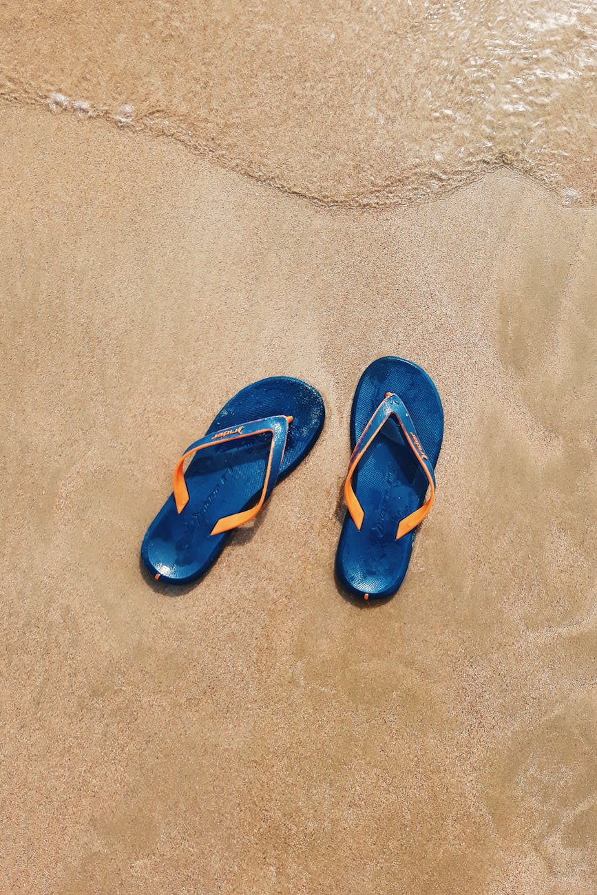 top view photo of slippers on seashore