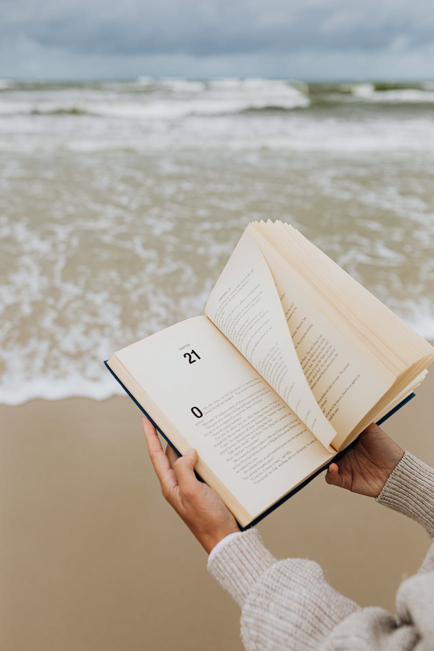 person reading a book on the beach