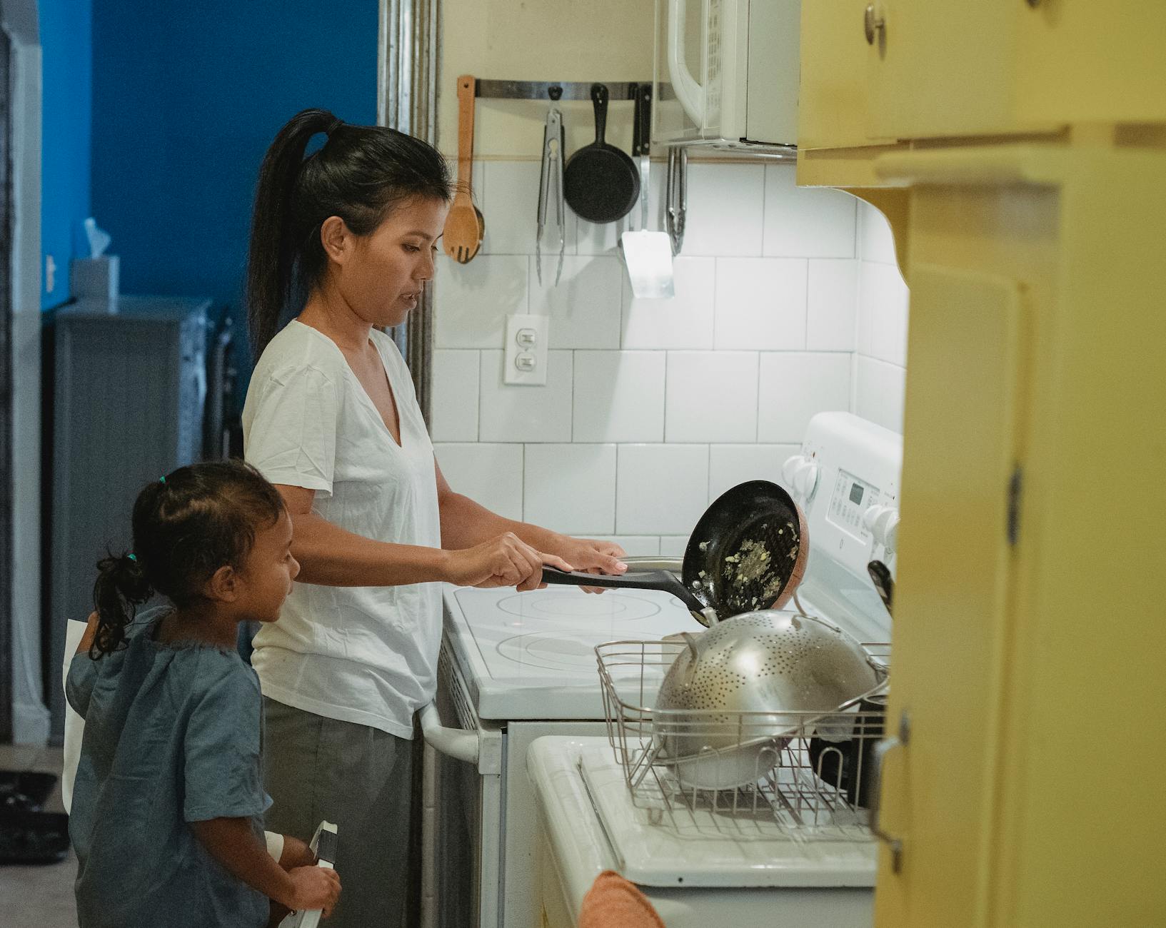 asian woman and daughter cooking lunch in modern kitchen