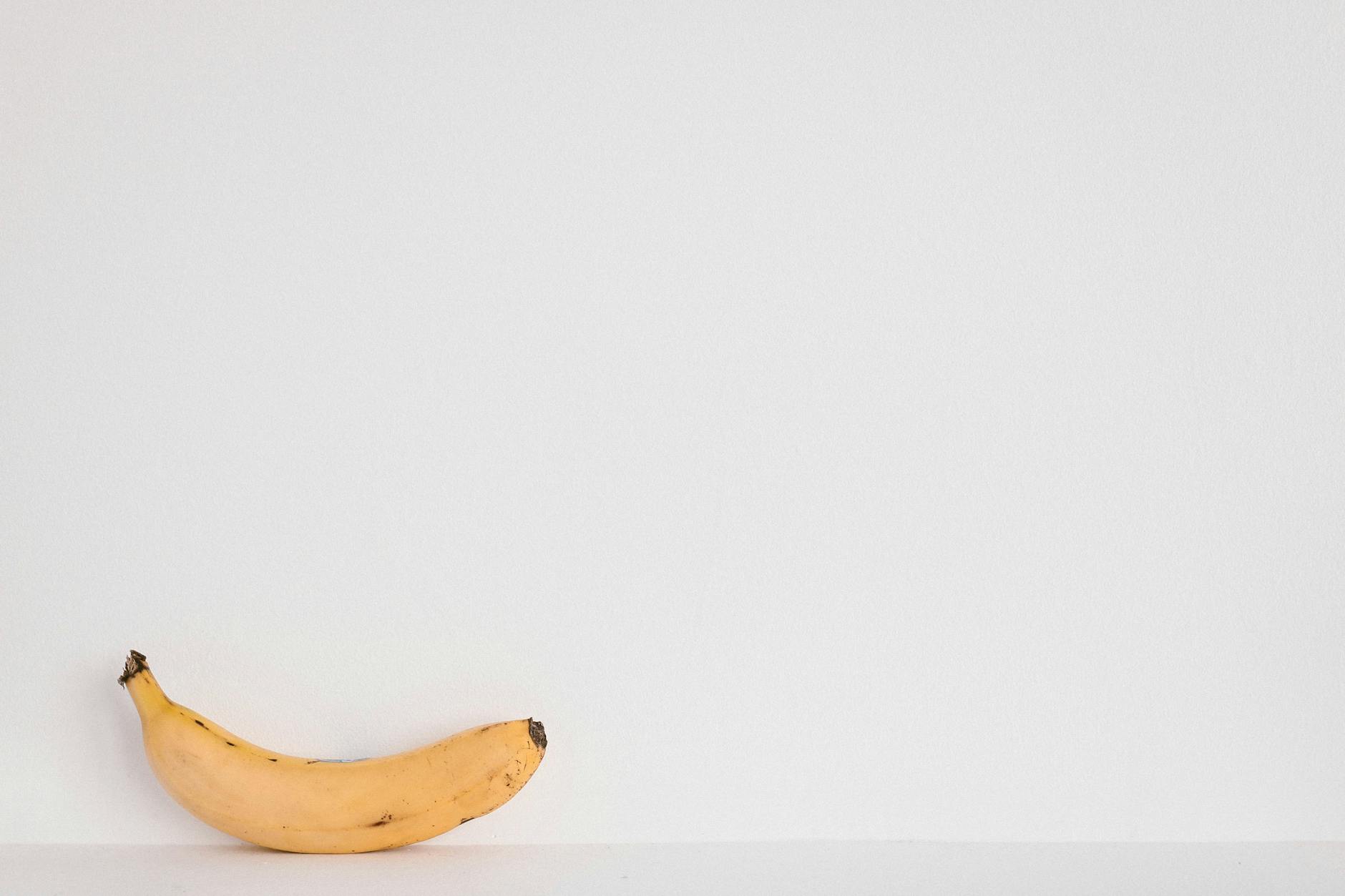 yellow banana fruit on white surface