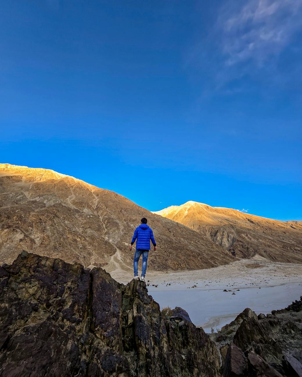 solo adventurer overlooking majestic mountain range