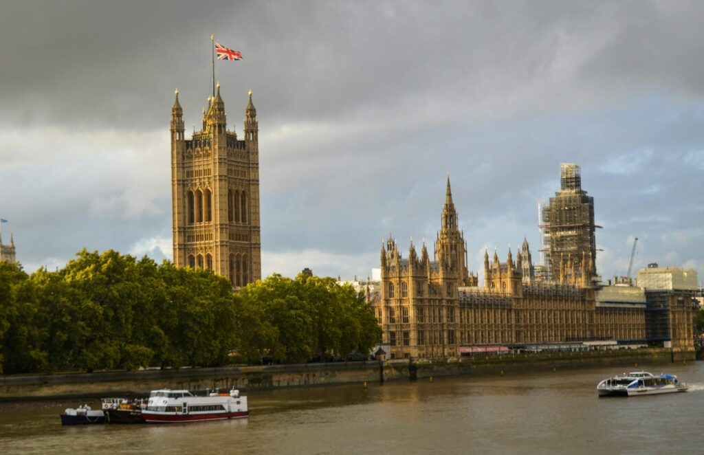 the westminster palace on green embankment of the river thames