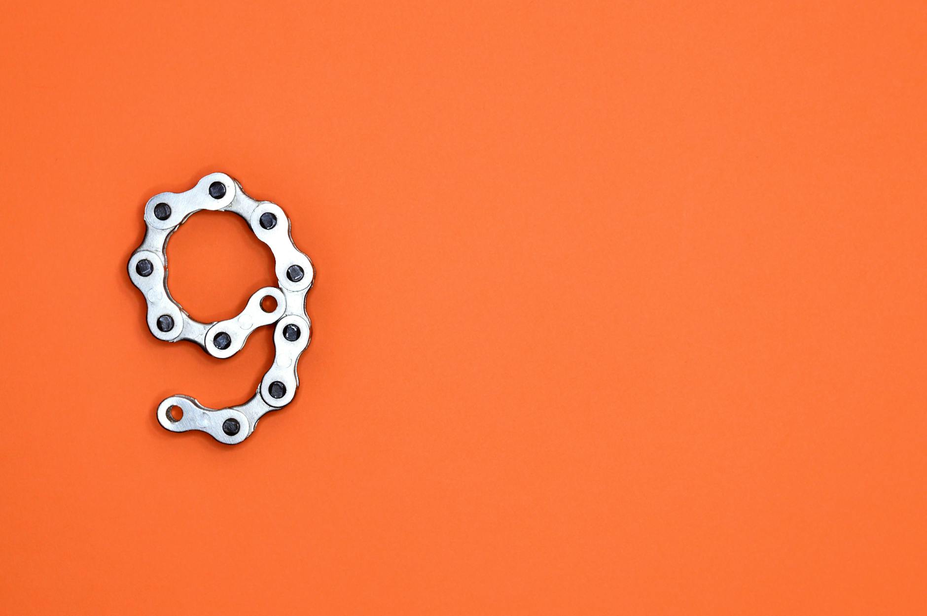 gray bicycle chain on orange surface