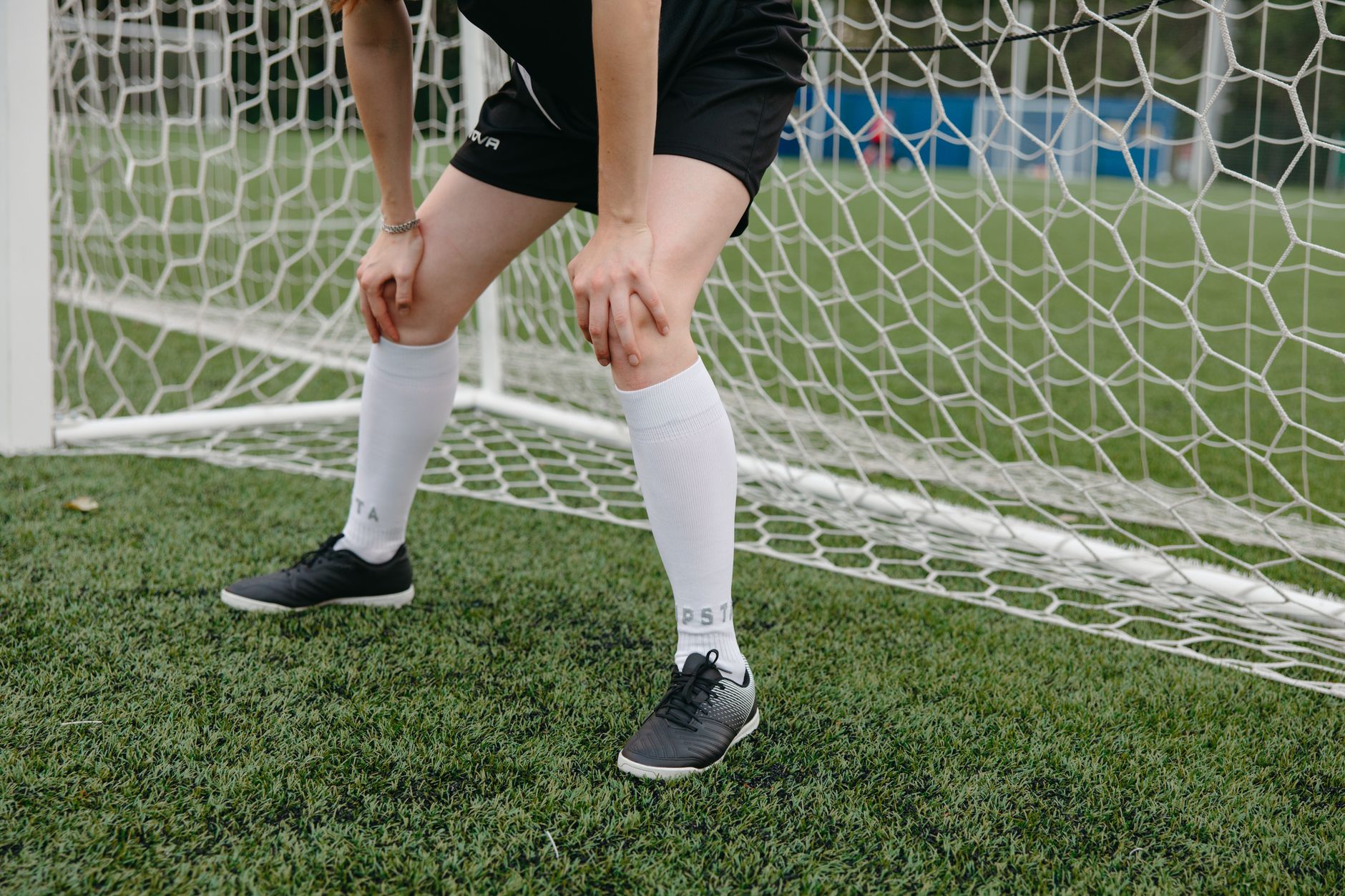 woman in black shorts standing on green grass field