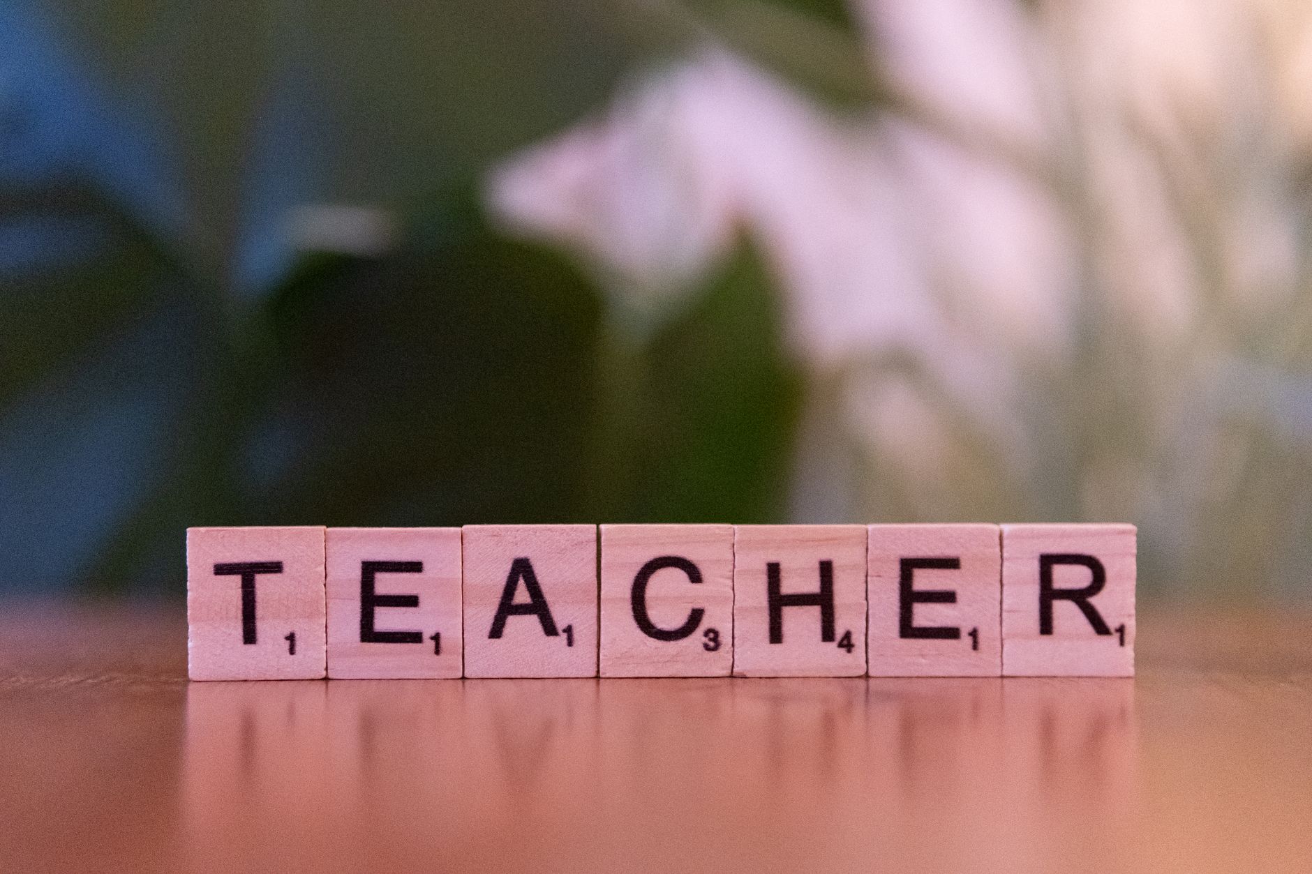 wooden scrabble tiles spelling teacher
