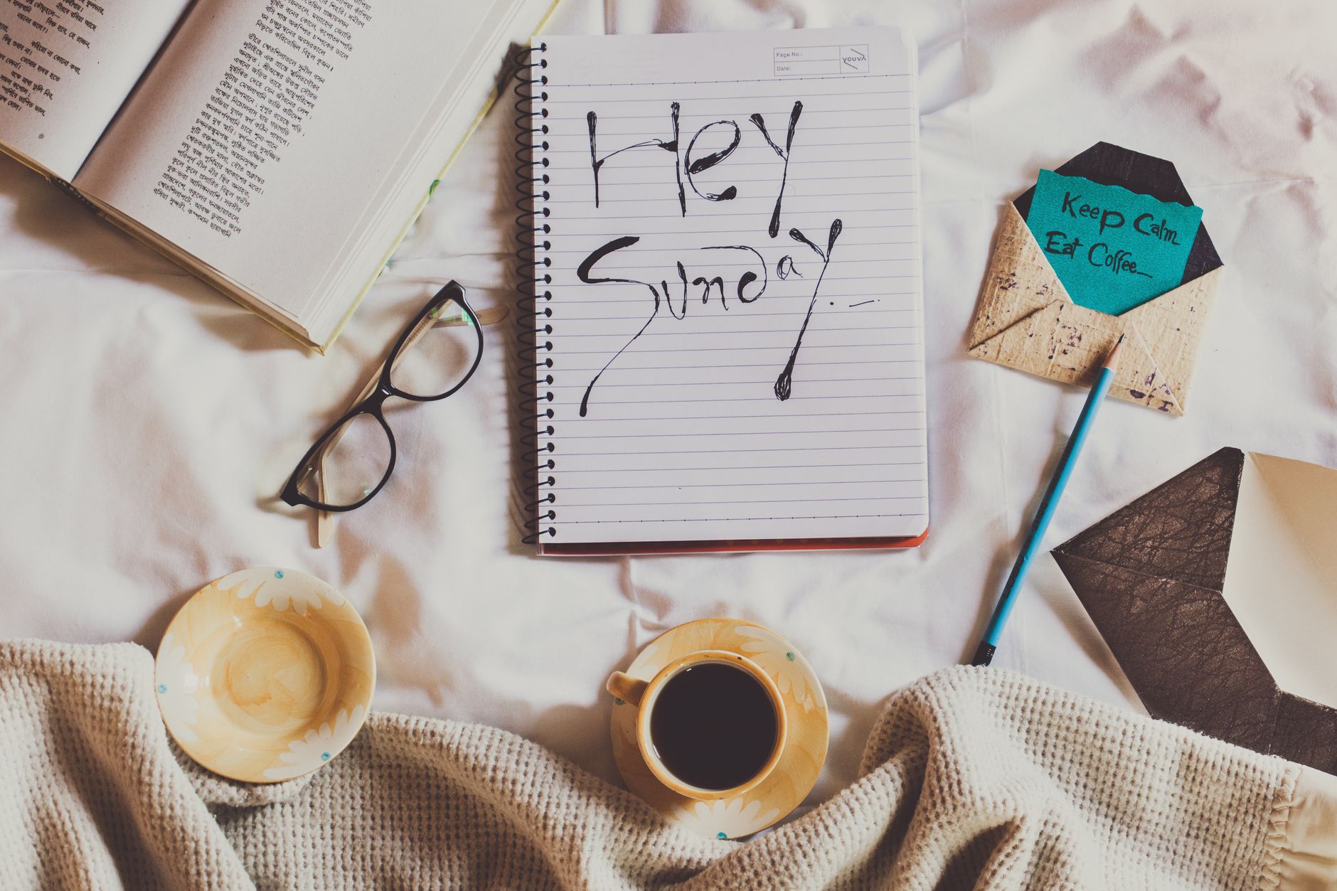 notebook with inscription near cup of coffee on crumpled fabric