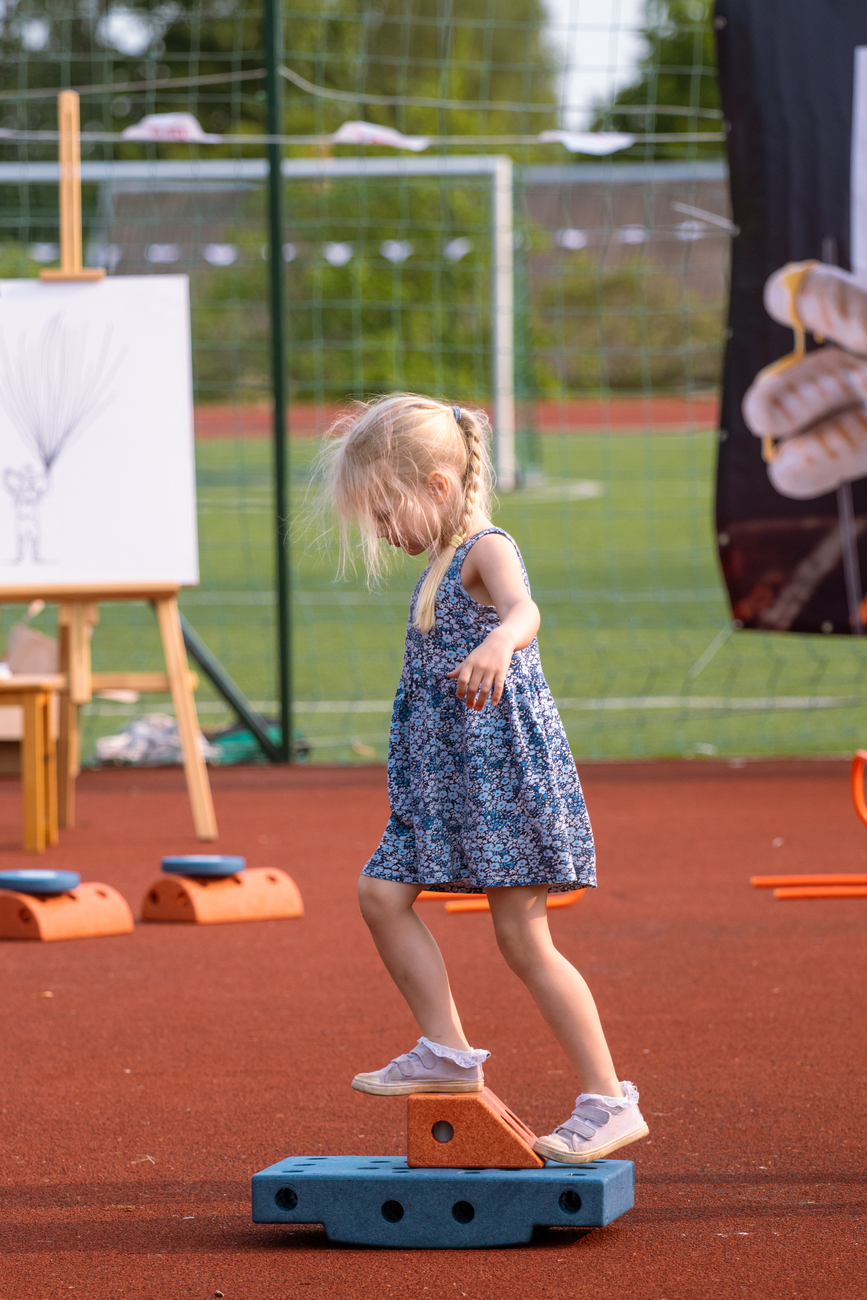 child balancing on play equipment outdoors