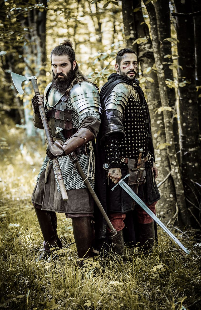 warriors standing in the forest while holding weapons