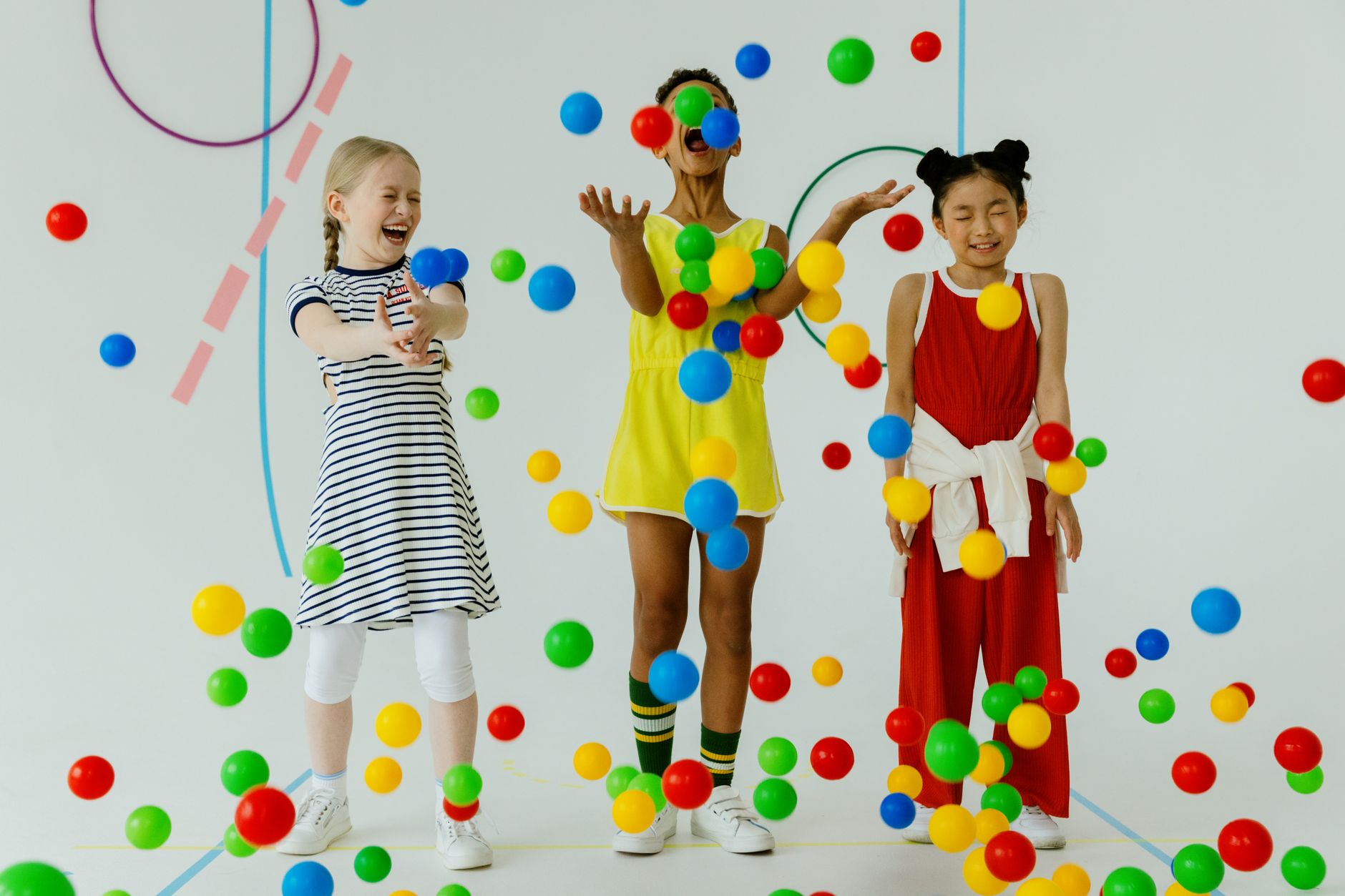 happy girls throwing colorful balls